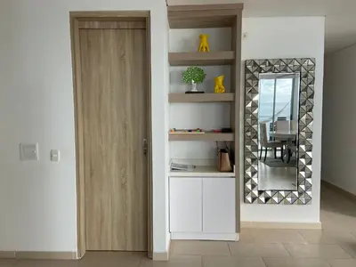 a living room with a mirror and a door at Espectacular apto frente al mar in Coveñas
