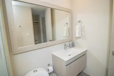 a bathroom with a sink and a mirror and a toilet at New & Comfortable Apartment In Cielo Mar in Cartagena de Indias