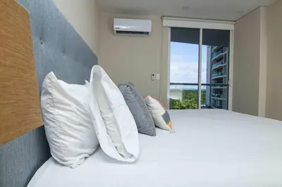 a bedroom with a bed with pillows and a window at New & Comfortable Apartment In Cielo Mar in Cartagena de Indias