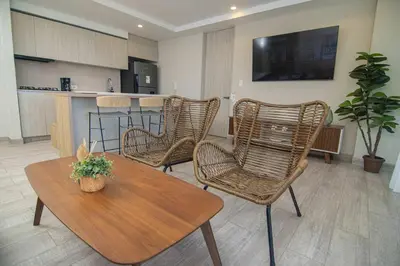 a living room with wicker chairs and a table at New & Comfortable Apartment In Cielo Mar in Cartagena de Indias