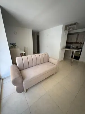a living room with a couch and a kitchen at Apartamento norte de Barranquilla in Barranquilla