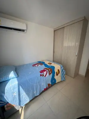 a bedroom with a bed with a blue comforter at Apartamento norte de Barranquilla in Barranquilla