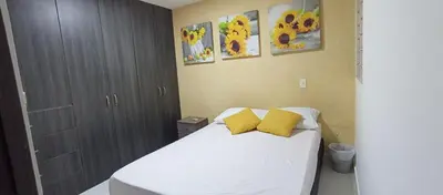 a bedroom with a bed with two yellow pillows at Turquesa a 5 Minutos del aereopuerto Daniel Lemaitre in Cartagena de Indias