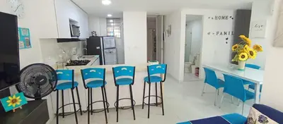 a kitchen with blue chairs and a counter with a fan at Turquesa a 5 Minutos del aereopuerto Daniel Lemaitre in Cartagena de Indias
