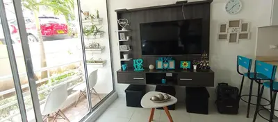 a living room with a television and a table and chairs at Turquesa a 5 Minutos del aereopuerto Daniel Lemaitre in Cartagena de Indias
