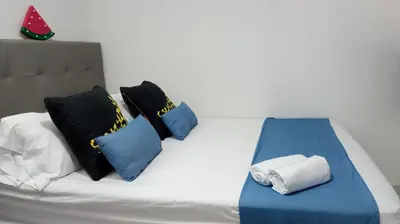 a bed with blue and black pillows on it at Comfy apartment in historic center in Cartagena de Indias
