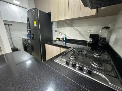 a kitchen with a stove and a refrigerator at Low cost 2A,TV 60 15 min B vista in Barranquilla