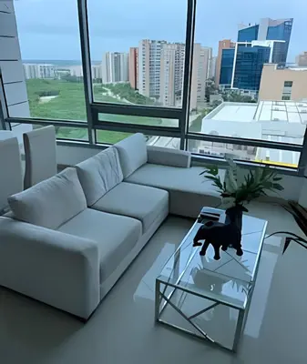 a living room with a white couch and a glass table at Apartamento en Bluegardens 1405 in Barranquilla