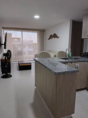 a kitchen with a counter and a living room at Hermoso apartamento in Cartagena de Indias