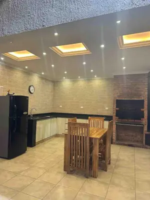 a dining room with a table and a refrigerator at Villa Maty Casa Campestre in Turbaco