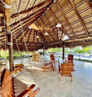a porch with chairs and a swinging porch swing at Villa Maty Casa Campestre in Turbaco
