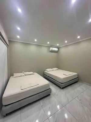two beds sitting in a room with at Villa Maty Casa Campestre in Turbaco