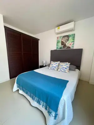 a bedroom with a large bed with a blue blanket at Apartamentos cerca al hotel Las Americas in Cartagena de Indias