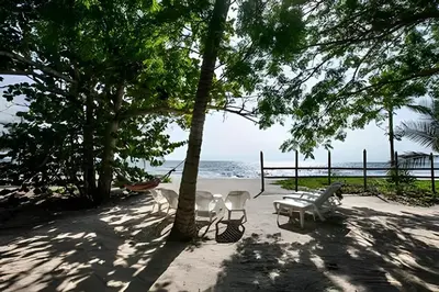a beach with chairs and trees and the ocean at Casa de playa Manglares in Tolú