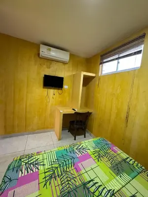 a bedroom with a bed and a desk and a television at Hostal Bambumar in Cartagena de Indias