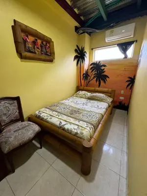 a bedroom with a bed and a chair in it at Hostal Bambumar in Cartagena de Indias
