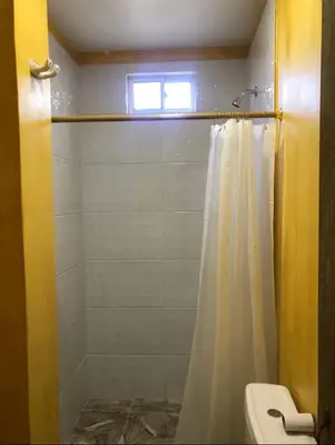 a bathroom with a shower with a white shower curtain at Hostal Bambumar in Cartagena de Indias