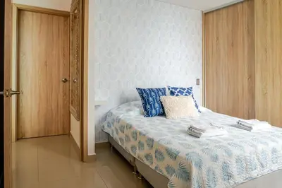 a bedroom with a bed with blue and white sheets at Paraíso Costero Apartamento de Lujo con Vista Directa al Mar in Cartagena de Indias