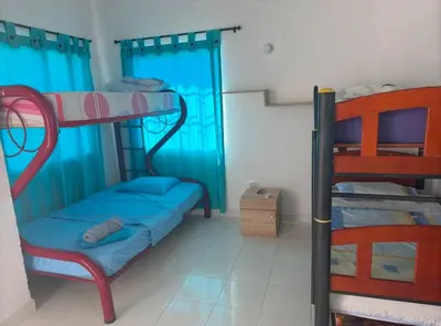 a bedroom with two bunk beds with blue curtains at Casa Campestre Valle del Mar in Santa Marta