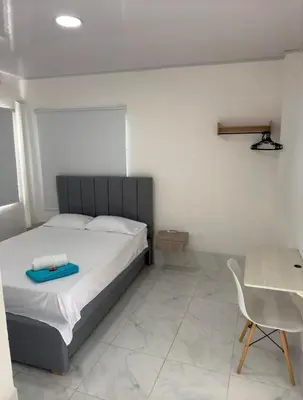 a bedroom with a bed and a table and a chair at Casa Campestre Valle del Mar in Santa Marta
