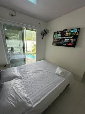 a white bed in a bedroom with a large window at Casa Campestre Valle del Mar in Santa Marta