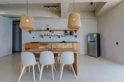 a kitchen with a wooden table and white chairs at HBE-P4 Penthouse Lujoso de 4 Habitaciones Frente al Mar con Wifi in Cartagena de Indias