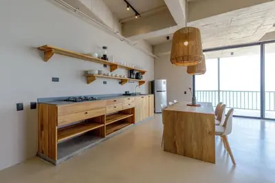 a kitchen with wooden cabinets and a table in a room at HBE-P4 Penthouse Lujoso de 4 Habitaciones Frente al Mar con Wifi in Cartagena de Indias
