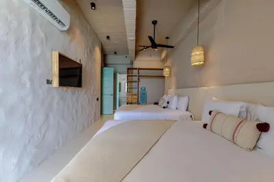 a bedroom with two beds and a wall with a tv at HBE-P4 Penthouse Lujoso de 4 Habitaciones Frente al Mar con Wifi in Cartagena de Indias