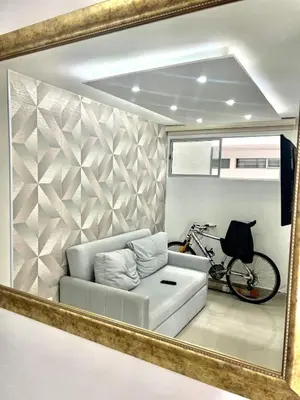 a mirror reflecting a living room with a couch and a bike at Nuevo apartamento de lujo con balcón wifi AC piscina in Barranquilla