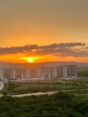 a city with the sun setting in the background at Nuevo apartamento de lujo con balcón wifi AC piscina in Barranquilla