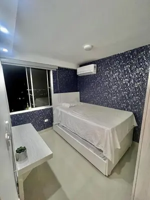 a small bedroom with a bed and a window at Nuevo apartamento de lujo con balcón wifi AC piscina in Barranquilla