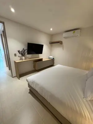 a bedroom with a large bed and a flat screen tv at Comfort Retreat in Bocagrande in Cartagena de Indias
