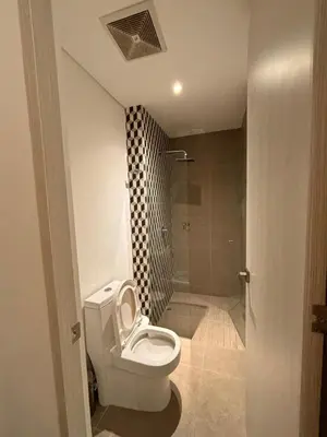 a bathroom with a white toilet and a shower at District Aptosuite 404 in Barranquilla