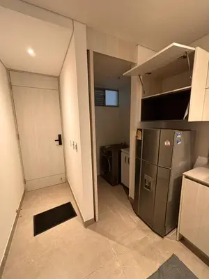 a small kitchen with a refrigerator and a door at District Aptosuite 404 in Barranquilla