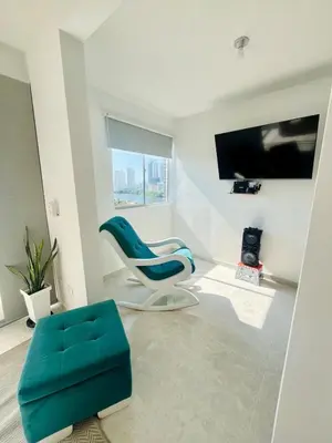 a living room with a blue chair and a tv at Beautiful view in Cartagena in Cartagena de Indias