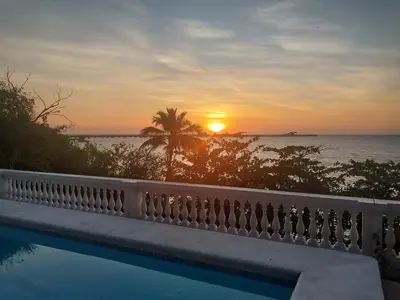 a view of the sunset from a swimming pool at Casa de playa vistamare in Santa Marta