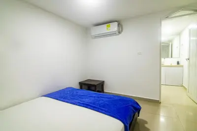 a white room with a bed with a blue blanket at Casa de playa vistamare in Santa Marta