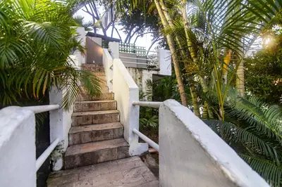 a staircase leading to a building with palm trees at Casa de playa vistamare in Santa Marta