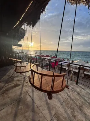 a swing on the beach with the ocean in the background at Euphoria Beach in Playa Blanca