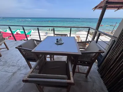 a table and chairs on a beach with the ocean at Euphoria Beach in Playa Blanca