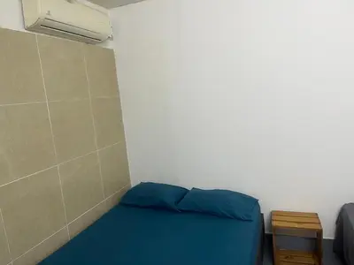 a small room with a blue bed and a wall at Habitación cerca de la playa 203 in Cartagena de Indias