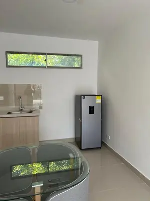 a kitchen with a glass table and a refrigerator at Casa ayola in Cartagena de Indias