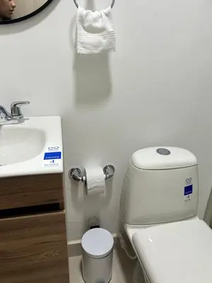 a white bathroom with a toilet and a sink at Casa ayola in Cartagena de Indias