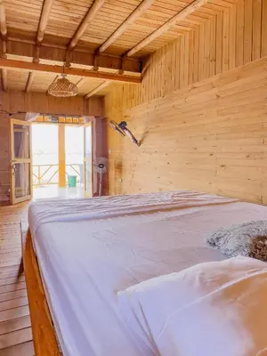 a bedroom with a large bed in a wooden wall at Hotel isla bonita in Tintipan Island