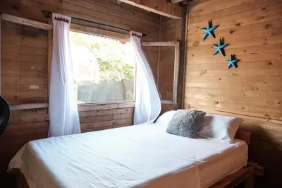 a bedroom with a bed and a window with stars on the wall at Hotel isla bonita in Tintipan Island