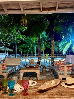 a patio with chairs and tables and palm trees at Casa de playa rústica en Tolú in San Silvestre