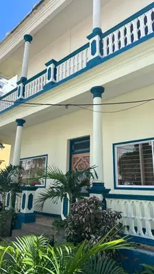 a white house with blue trim and a balcony at Apartamento de la A samblea in Cartagena de Indias