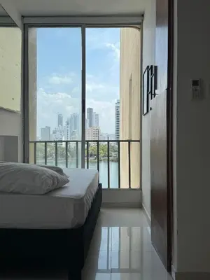 a bedroom with a bed and a large window at Encantador Apartamento El Laguito Bocagrande in Cartagena de Indias