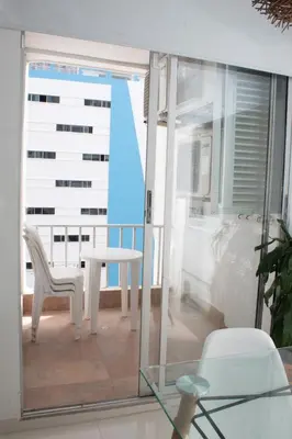 a balcony with a table and chairs and a window at Encantador Apartamento El Laguito Bocagrande in Cartagena de Indias