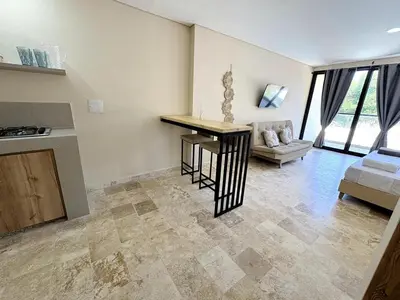 a kitchen and living room with a table and a couch at Apartment in Coveñas FOREST in Coveñas